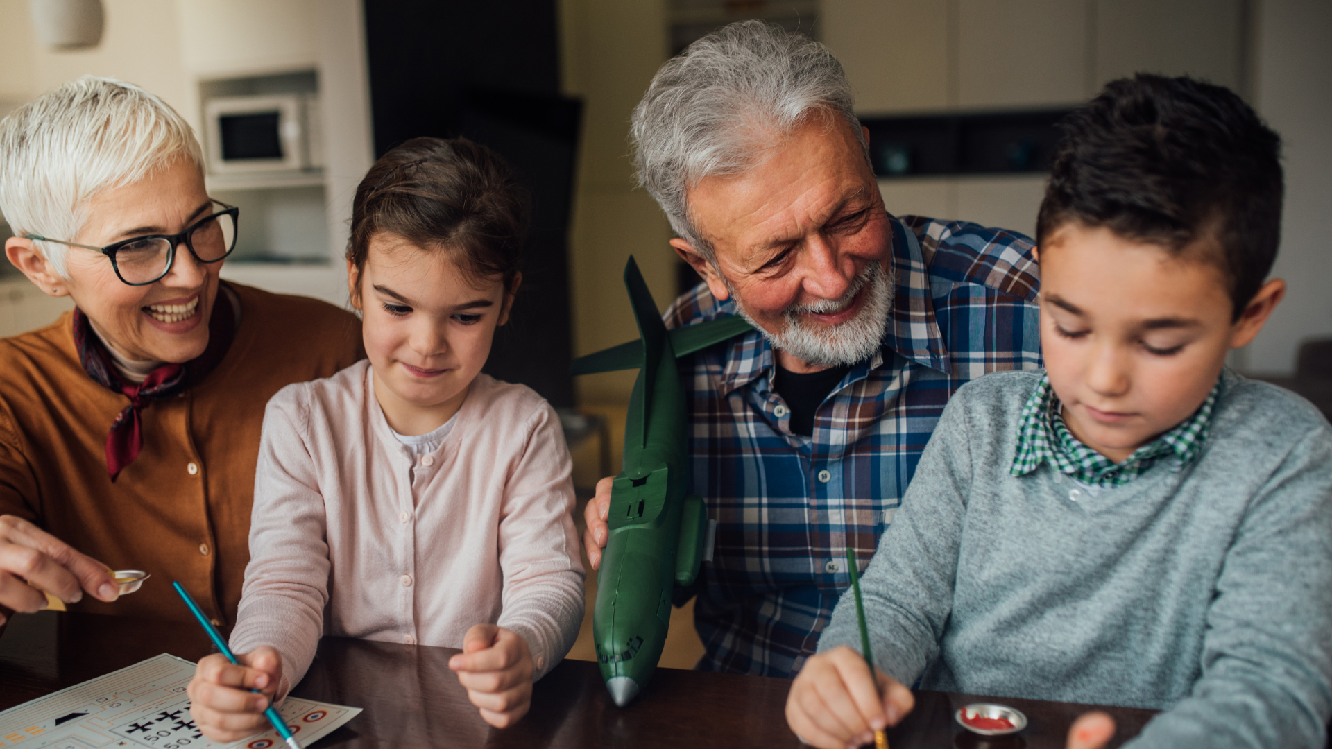 A multigenerational family gathered together looking at a tablet with children